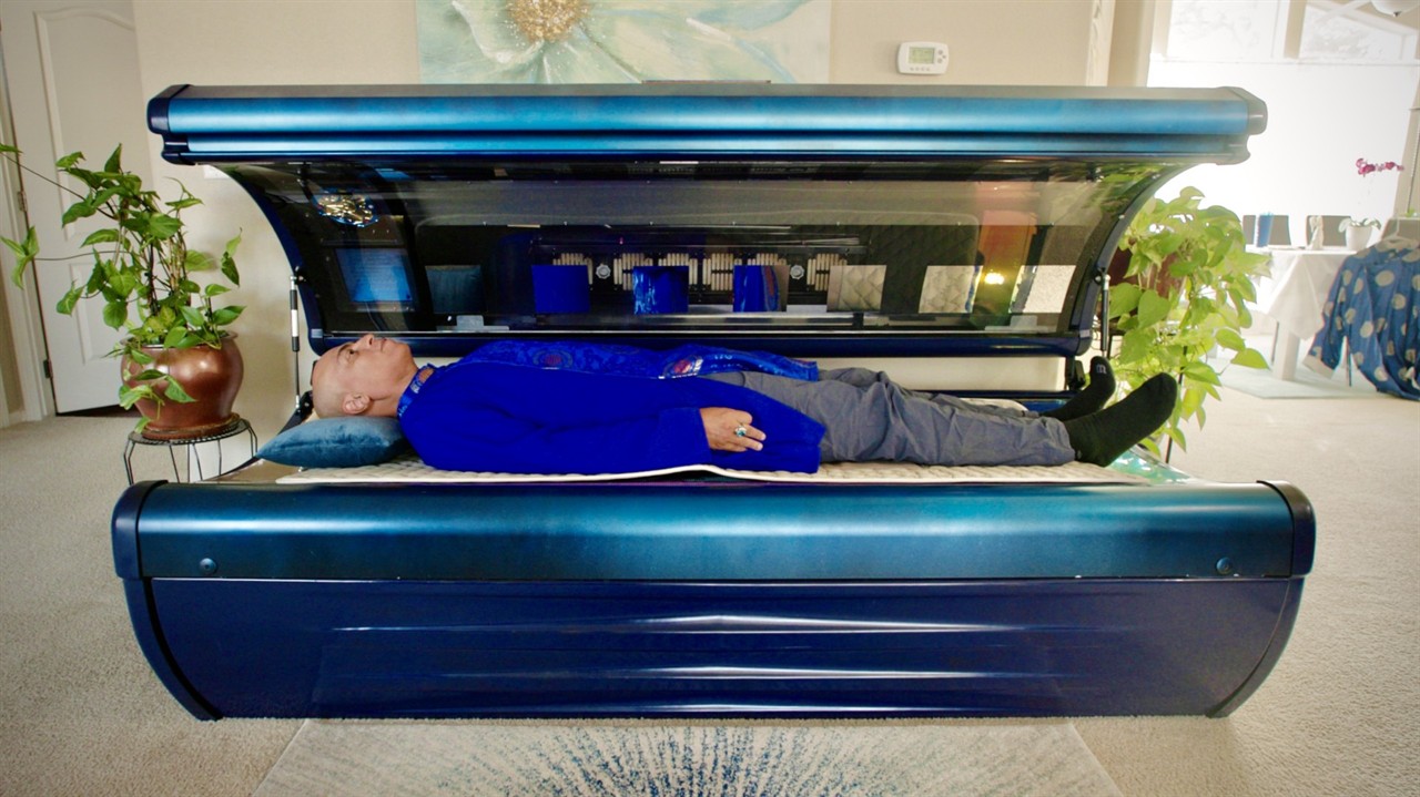 Man fully clothed, lying in a tanning bed